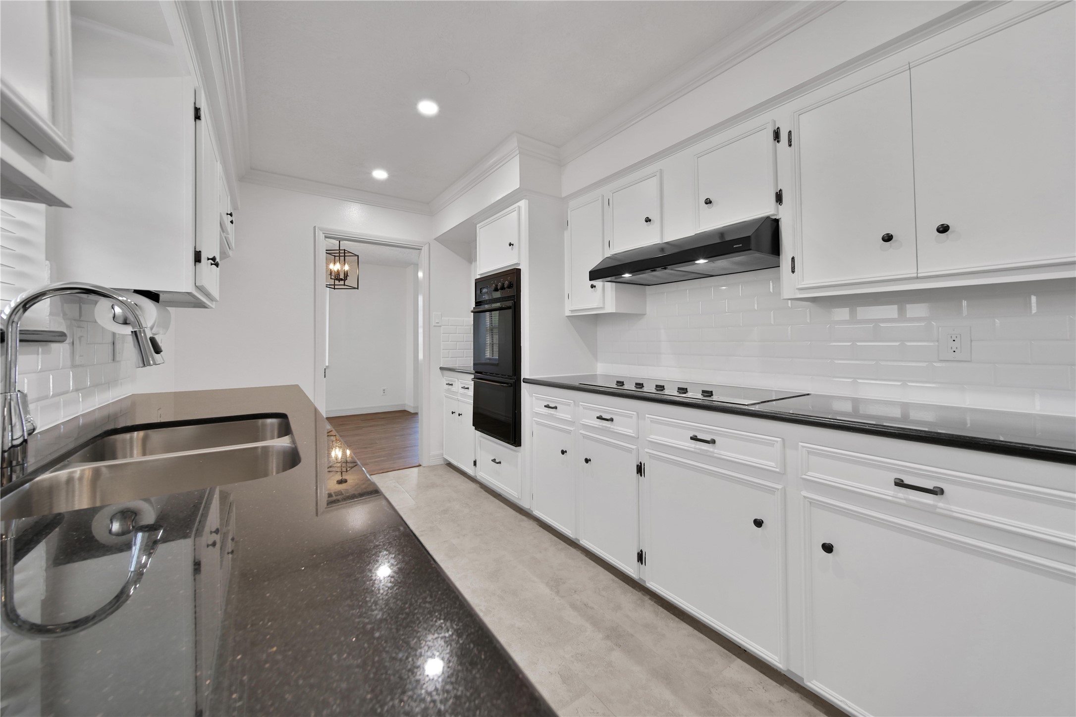 9411 Roos Road Houston, TX 77036 - Photo 18 of 41 a kitchen with granite countertop white cabinets and stainless steel appliances