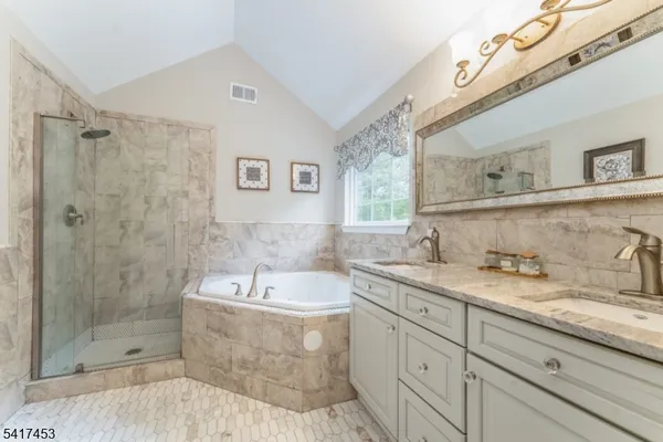 a bathroom with a granite countertop sink mirror and bathtub