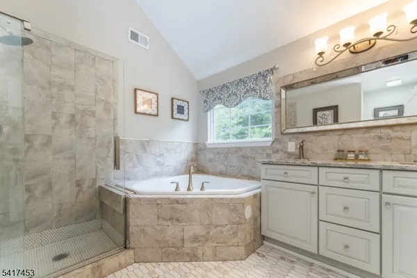 a bathroom with a bathtub sink and mirror