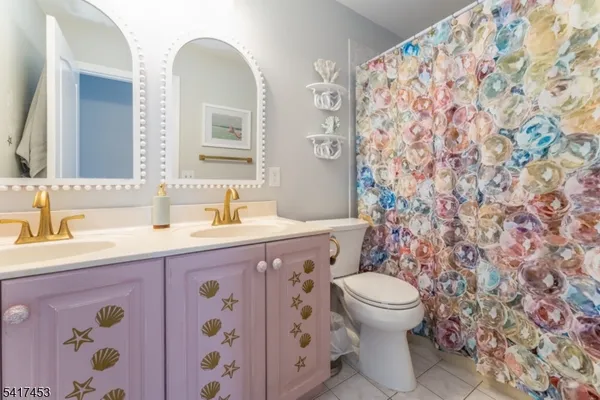 a bathroom with a granite countertop sink a toilet and a mirror