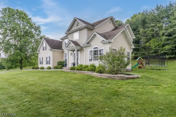 a front view of a house with a yard and trees
