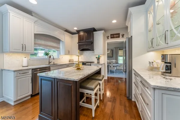 a kitchen with granite countertop a sink stove and cabinets