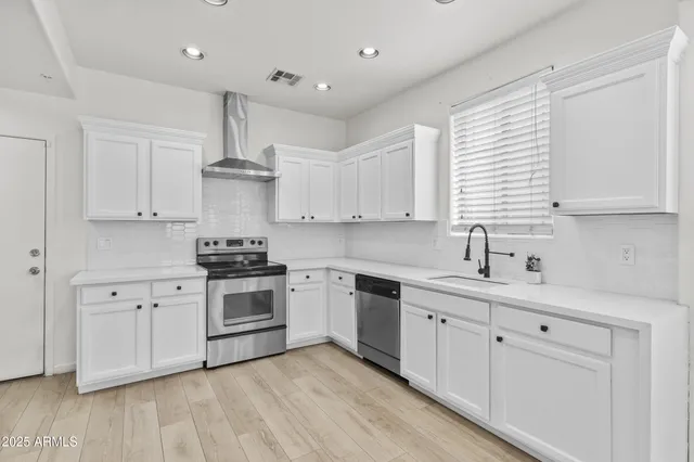 a kitchen with white cabinets stainless steel appliances and sink
