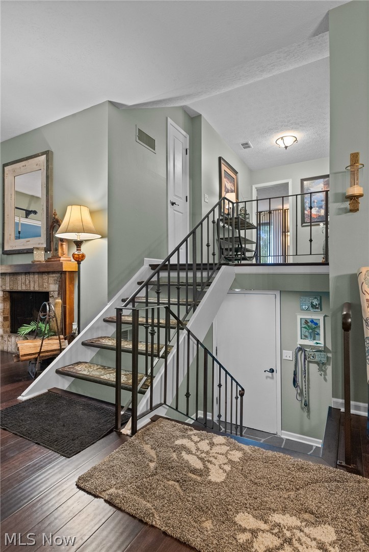 171 Granger Road, Unit 107 Medina, OH 44256 - Photo 18 of 41 Multi-level interior featuring Bamboo wood flooring, a stone fireplace, and a white staircase with black metal railings