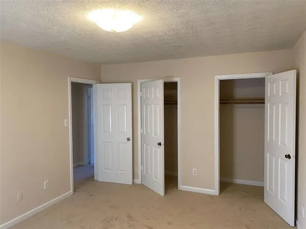 an empty room with windows and closet