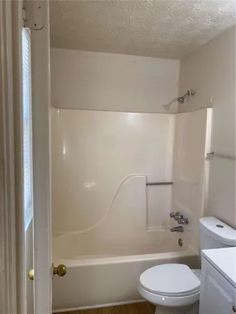 a white toilet and tub sitting next to a bathroom sink