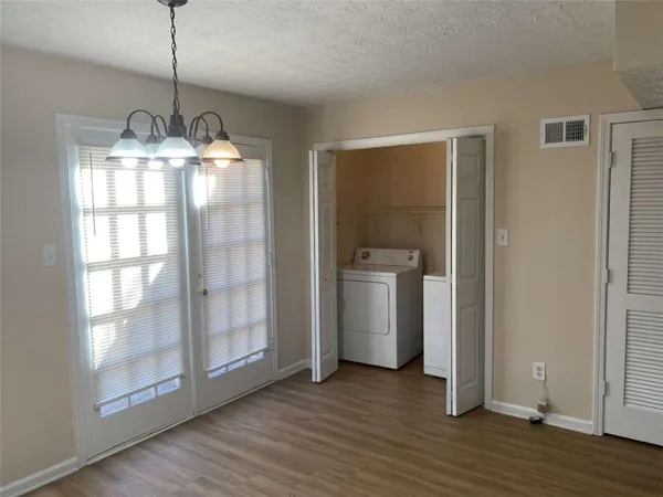 a view of a room with wooden floor kitchen and windows