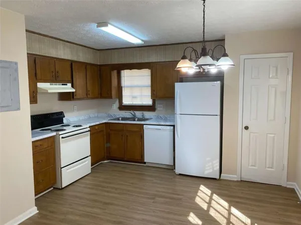 a kitchen with stove cabinets and wooden floor