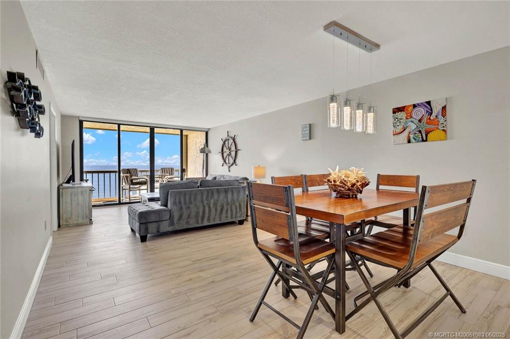 10600 South Ocean Drive, Unit 802 Jensen Beach, FL 34957 - Photo 11 of 39 a view of a dining room with furniture window and wooden floor