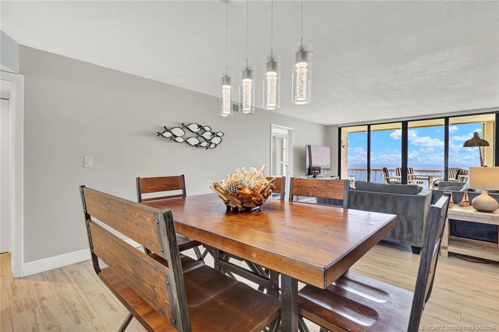 10600 South Ocean Drive, Unit 802 Jensen Beach, FL 34957 - Photo 12 of 39 a view of a dining room with furniture and a chandelier