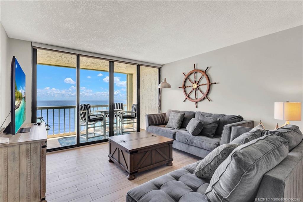 10600 South Ocean Drive, Unit 802 Jensen Beach, FL 34957 - Photo 15 of 39 a living room with furniture and a large window with wooden floor