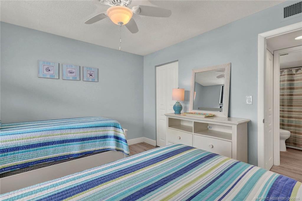 10600 South Ocean Drive, Unit 802 Jensen Beach, FL 34957 - Photo 27 of 39 a bedroom with a bed and a chandelier
