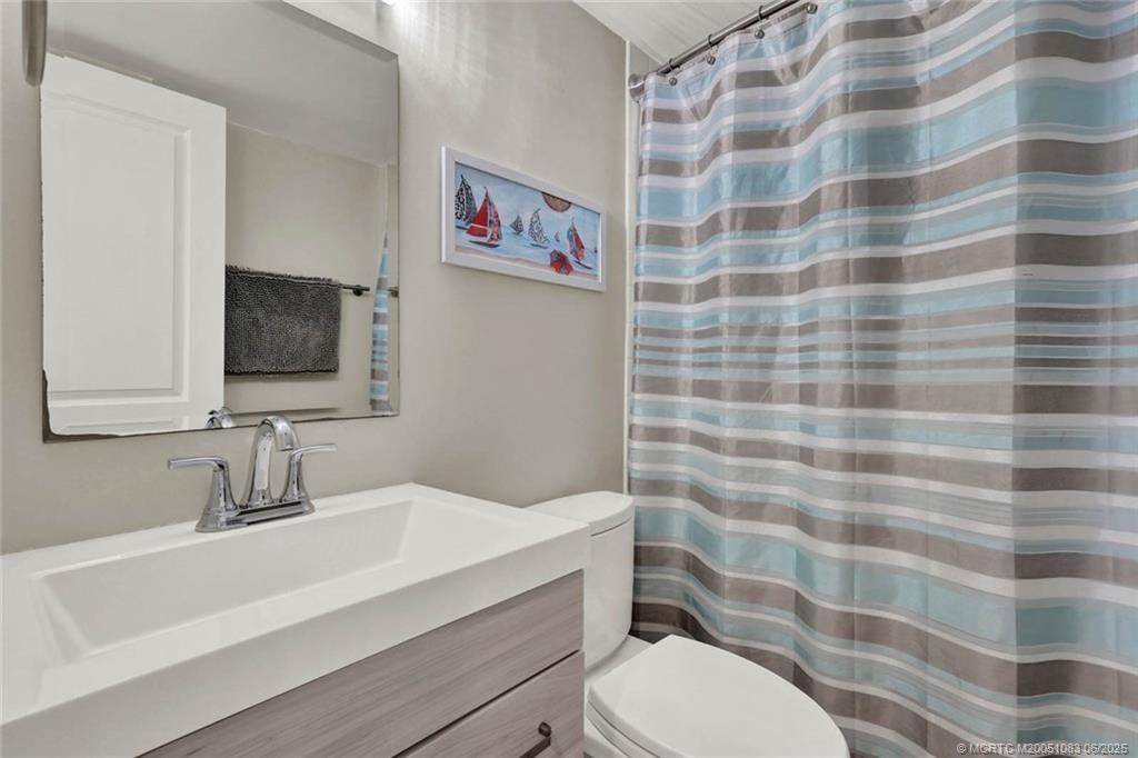 10600 South Ocean Drive, Unit 802 Jensen Beach, FL 34957 - Photo 28 of 39 a bathroom with a sink toilet and a mirror