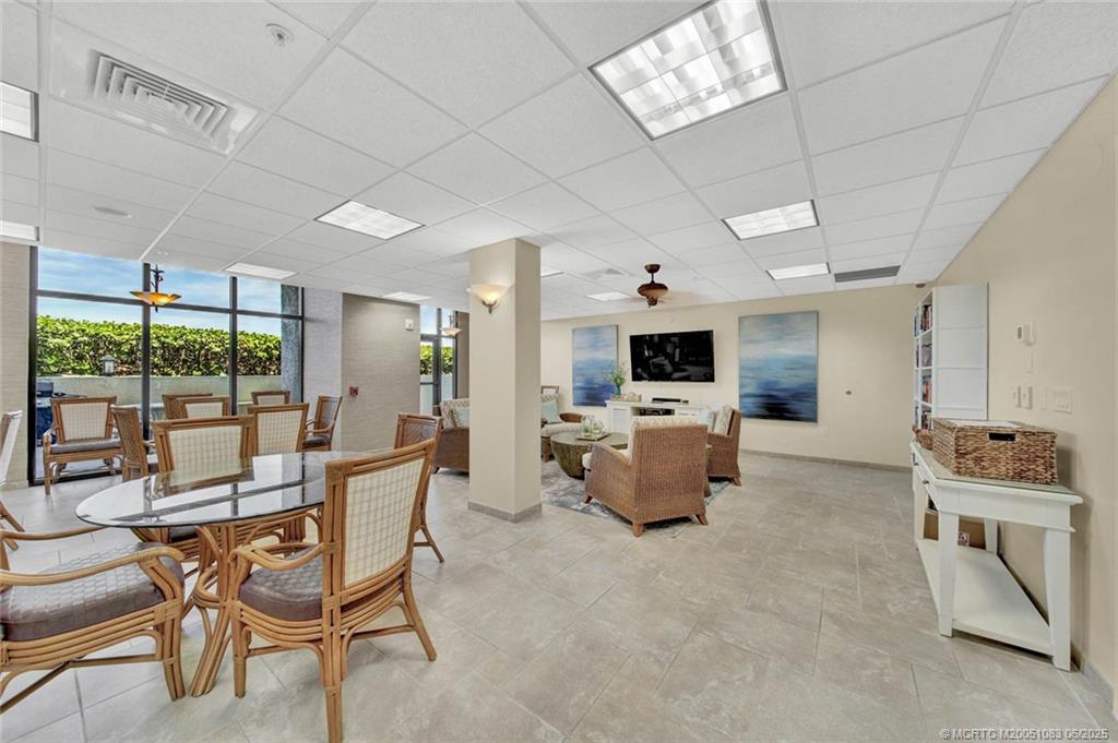 10600 South Ocean Drive, Unit 802 Jensen Beach, FL 34957 - Photo 30 of 39 a dining room with furniture a flat screen tv and a large window