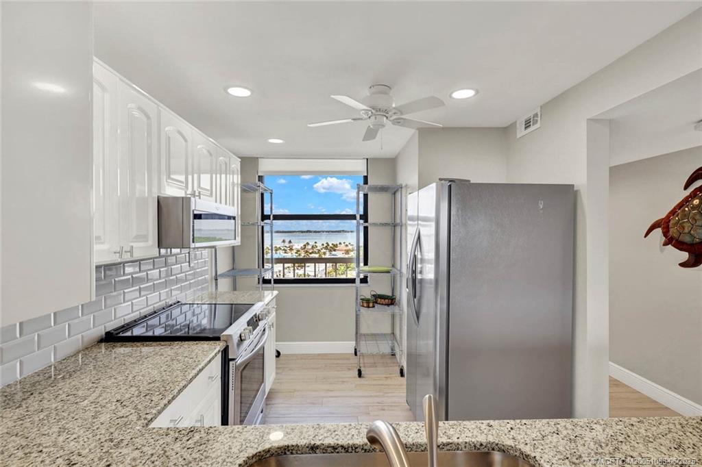 10600 South Ocean Drive, Unit 802 Jensen Beach, FL 34957 - Photo 9 of 39 a kitchen with stainless steel appliances granite countertop a refrigerator and a stove top oven