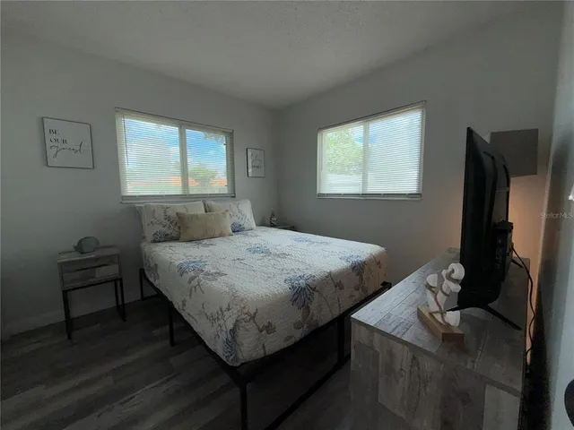 a bedroom with a bed tv and a window