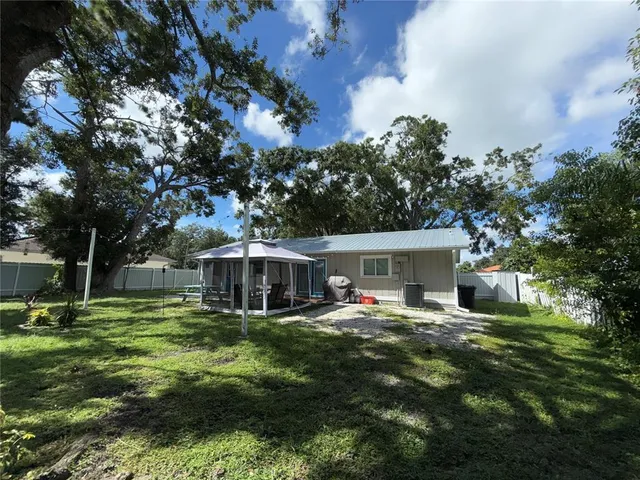 a view of a house with backyard and sitting area