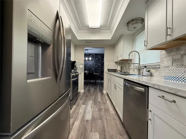 a kitchen with kitchen island granite countertop lots of counter top space and wooden floor