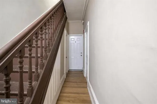 a view of a hallway with wooden floor and entryway