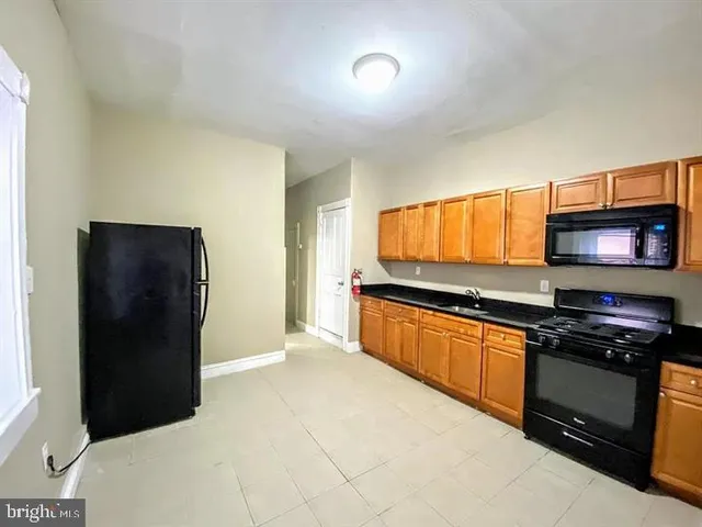 a kitchen with stainless steel appliances granite countertop a refrigerator and a stove