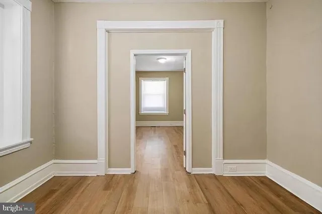 a view of a room with wooden floor and a window