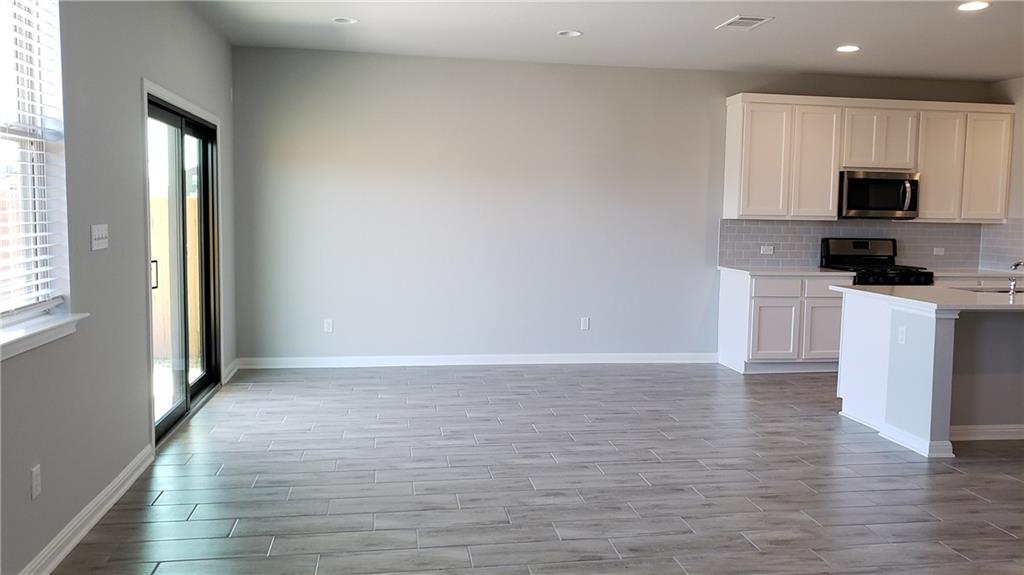 1508 Whippletree Trail Georgetown, TX 78626 - Photo 3 of 30 a view of a kitchen with a sink a microwave and cabinets