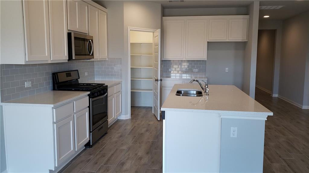 1508 Whippletree Trail Georgetown, TX 78626 - Photo 4 of 30 a kitchen that has a sink and a stove top oven