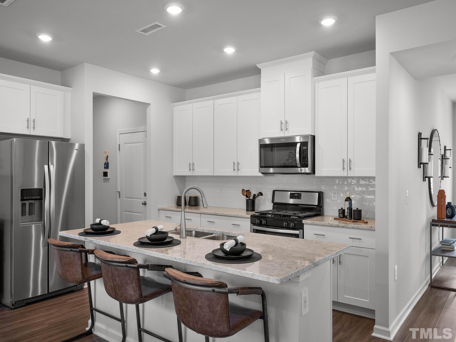 3000 Farndale Trace Durham, NC 27712 - Photo 3 of 14 a kitchen with stainless steel appliances a stove a sink a microwave a refrigerator and cabinets