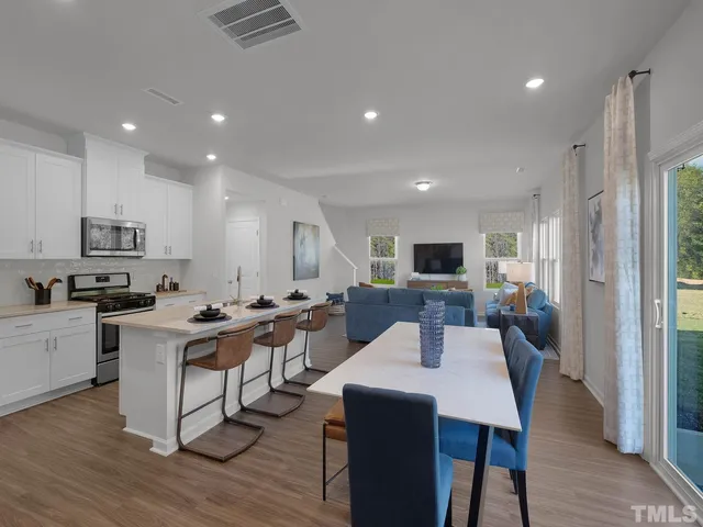 a view of a dining room with furniture a rug and wooden floor