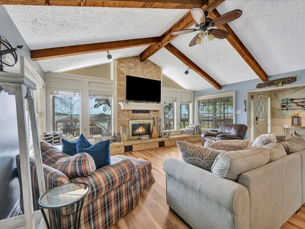 a living room with furniture a fireplace and a flat screen tv