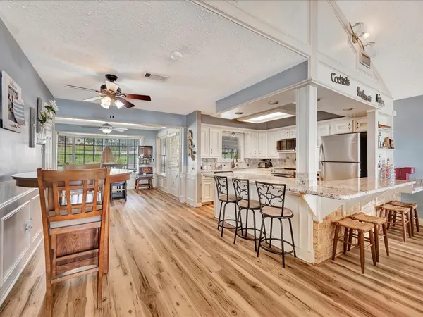 a view of a a dining room with furniture window and wooden floor