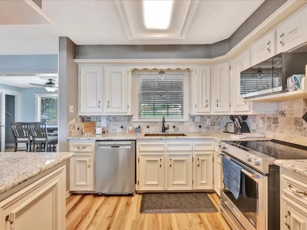 a kitchen with a white cabinets stove and sink