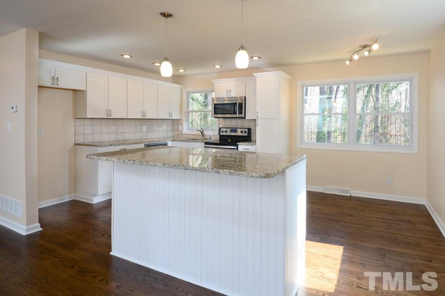 1717 Euclid Road Durham, NC 27713 - Photo 2 of 16 a kitchen with kitchen island a counter top space a sink stainless steel appliances and cabinets