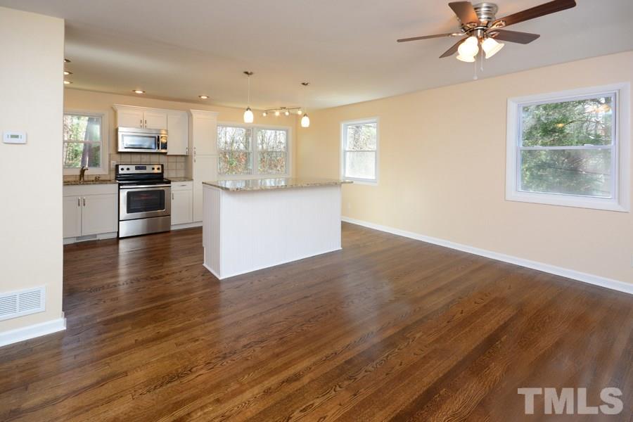 1717 Euclid Road Durham, NC 27713 - Photo 5 of 16 a kitchen with stainless steel appliances wooden floor and a refrigerator