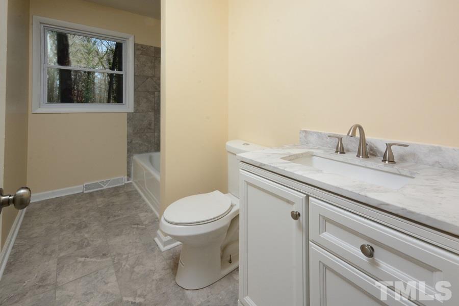 1717 Euclid Road Durham, NC 27713 - Photo 8 of 16 a bathroom with a granite countertop toilet sink and mirror