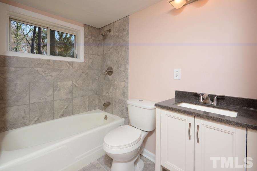 1717 Euclid Road Durham, NC 27713 - Photo 9 of 16 a bathroom with a granite countertop toilet a sink and bathtub
