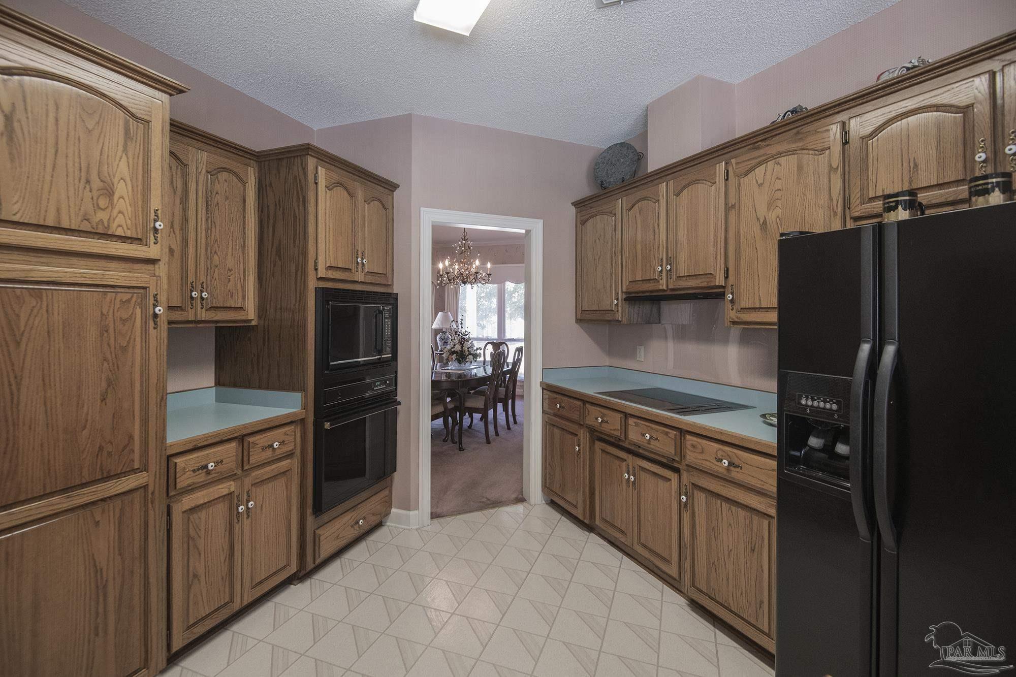 1505 Kings Road Cantonment, FL 32533 - Photo 16 of 57 a kitchen with stainless steel appliances granite countertop a refrigerator and a stove top oven