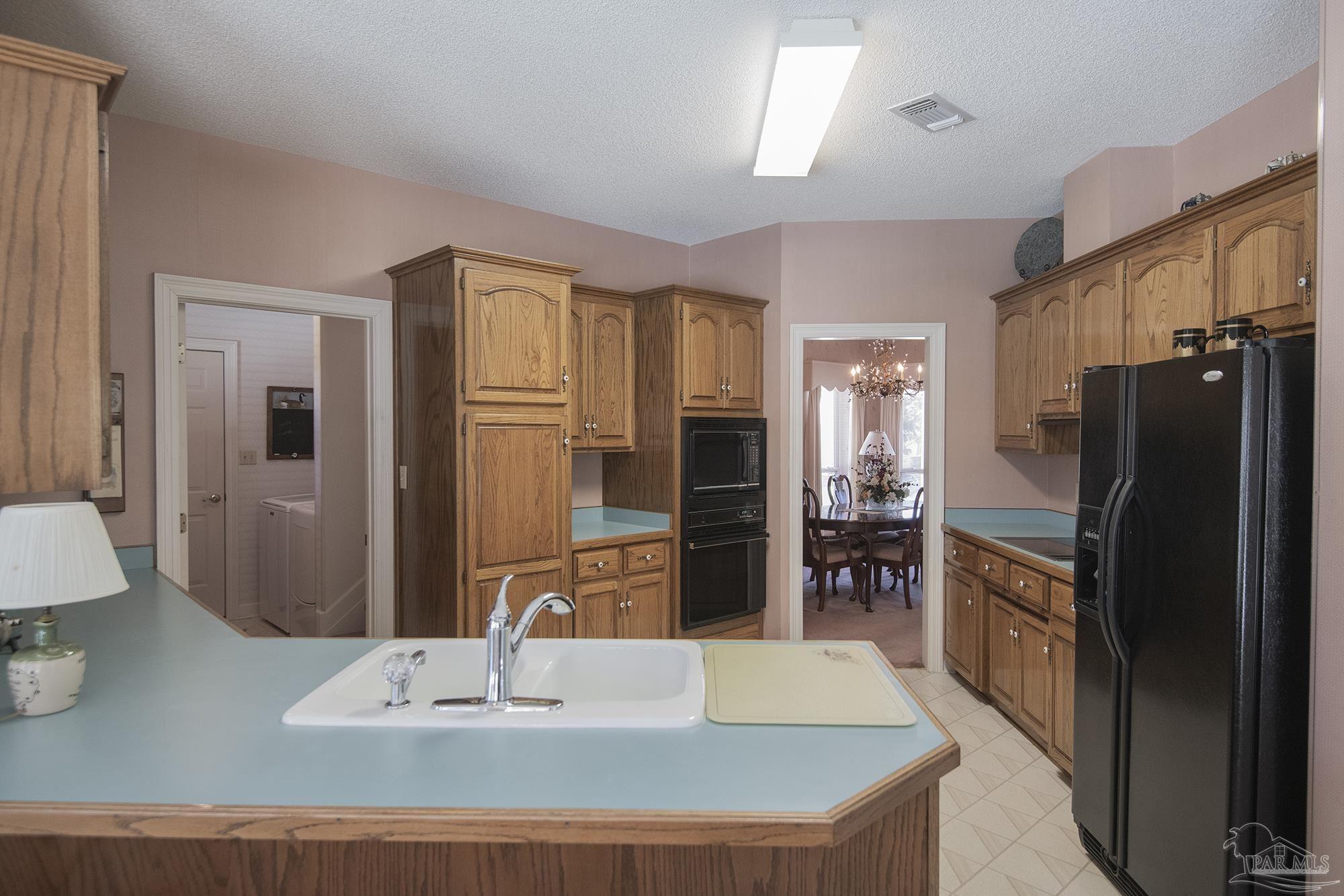 1505 Kings Road Cantonment, FL 32533 - Photo 21 of 57 a kitchen with stainless steel appliances granite countertop a refrigerator a stove and a sink
