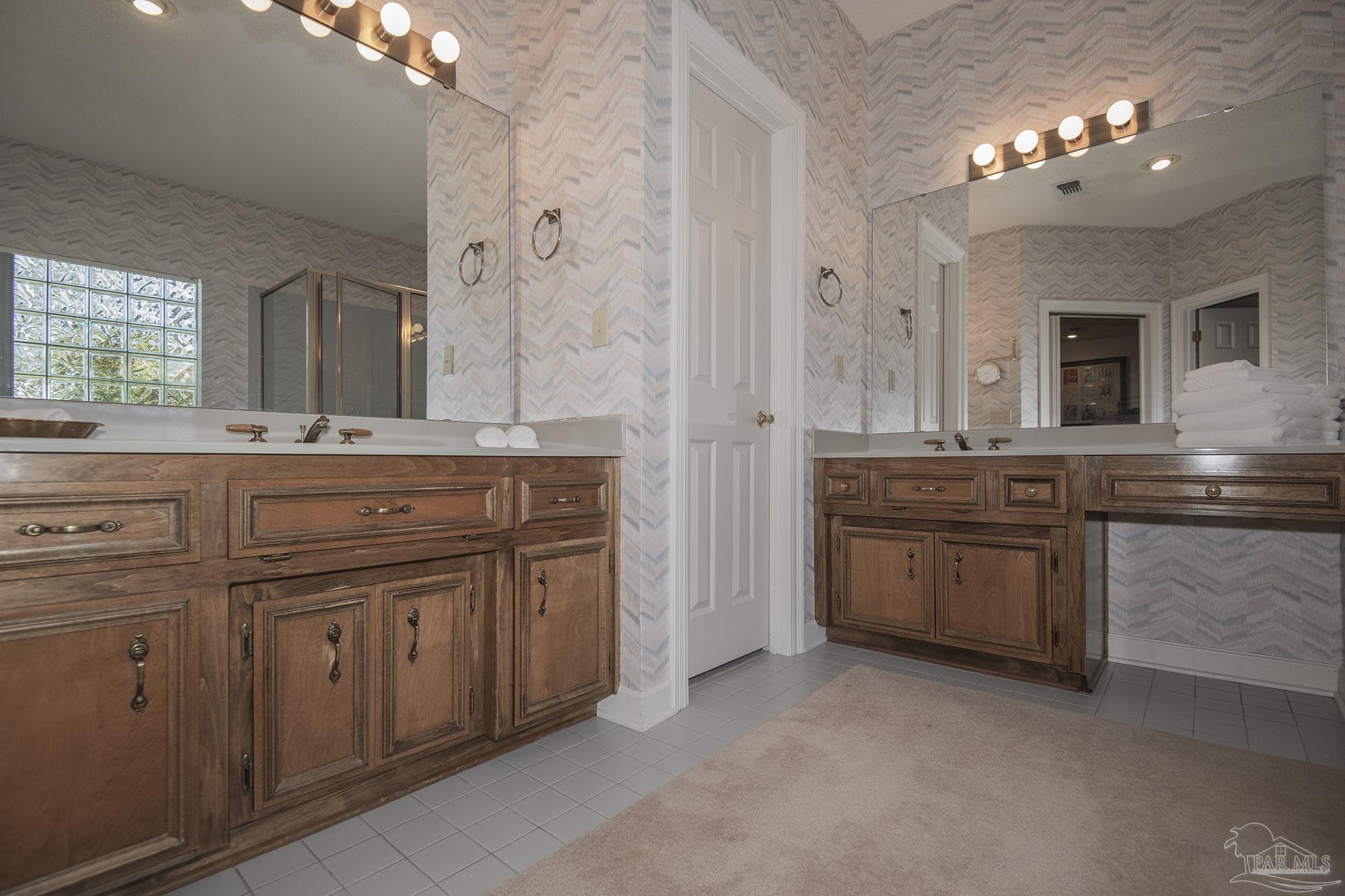 1505 Kings Road Cantonment, FL 32533 - Photo 32 of 57 a spacious bathroom with a granite countertop double vanity sink and a mirror