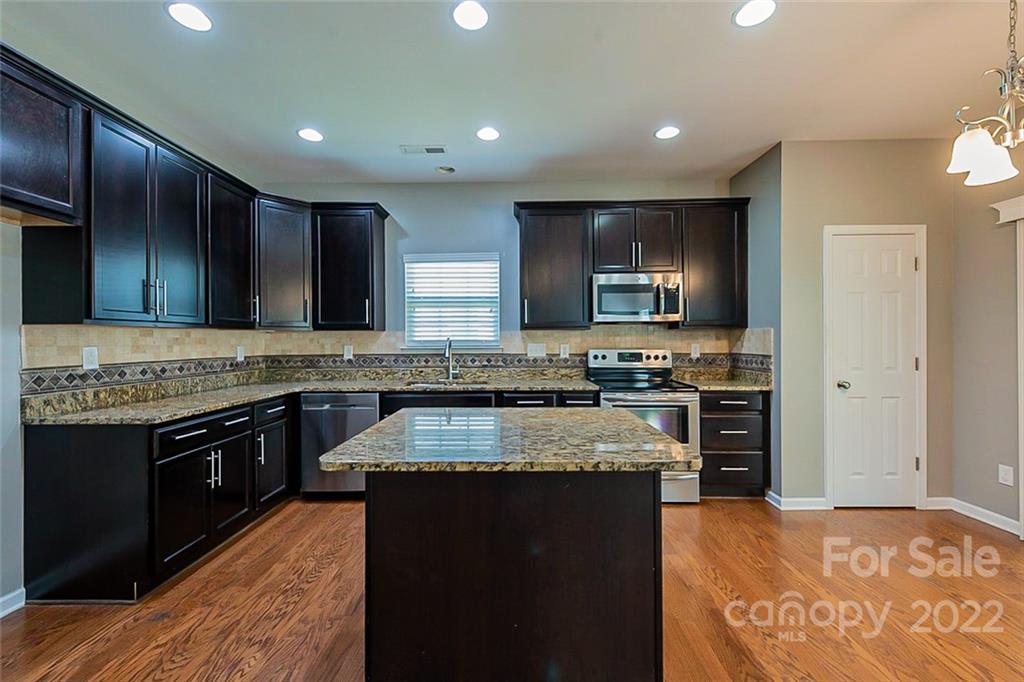 1629 Beleek Ridge Lane Clover, SC 29710 - Photo 7 of 23 a large kitchen with granite countertop stainless steel appliances and wooden cabinets