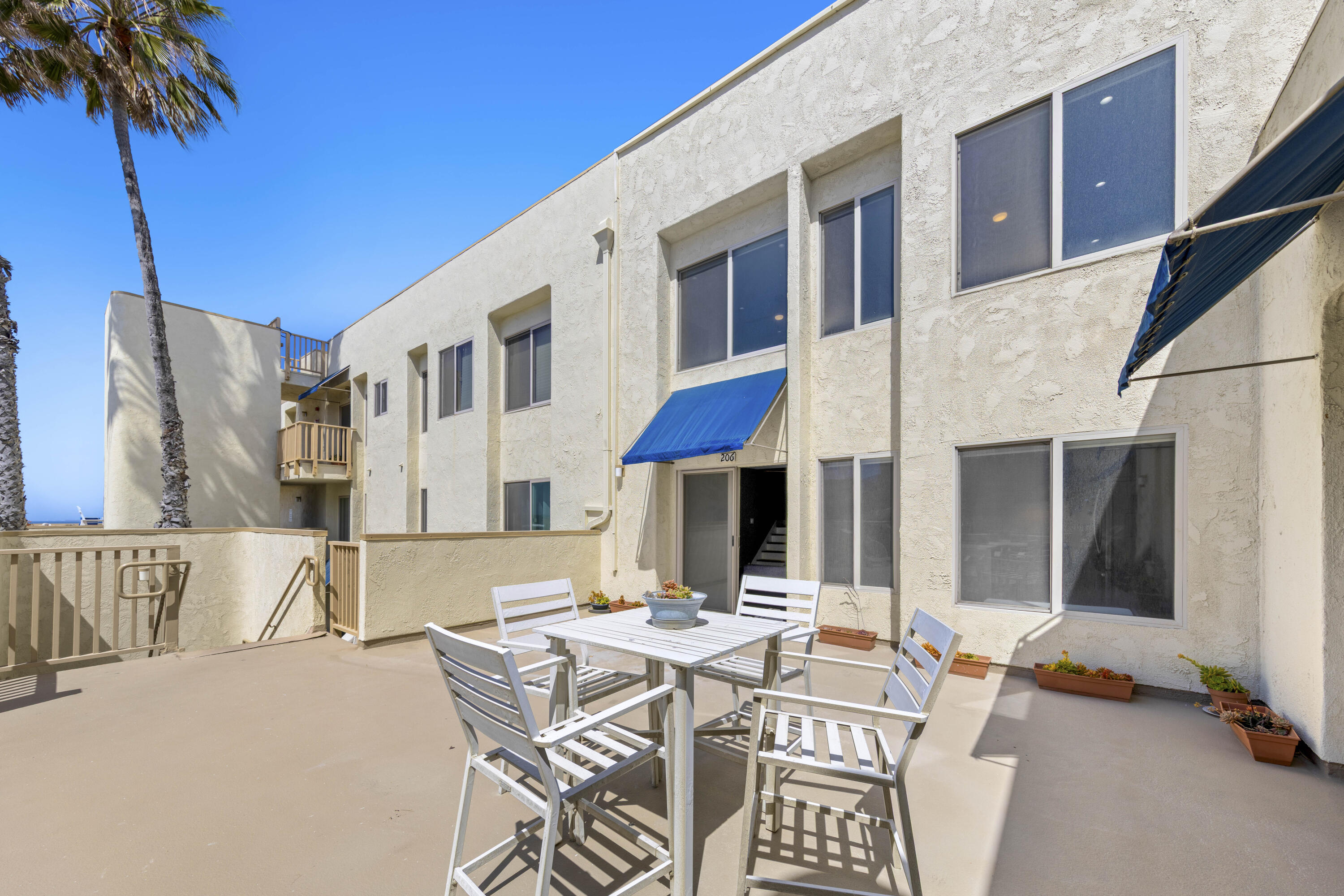 711 Pacific Coast Highway, Unit 206 Huntington Beach, CA 92648 - Photo 22 of 32 a view of a patio with a table and chairs