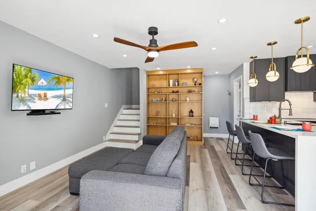 a living room with furniture kitchen view and a chandelier