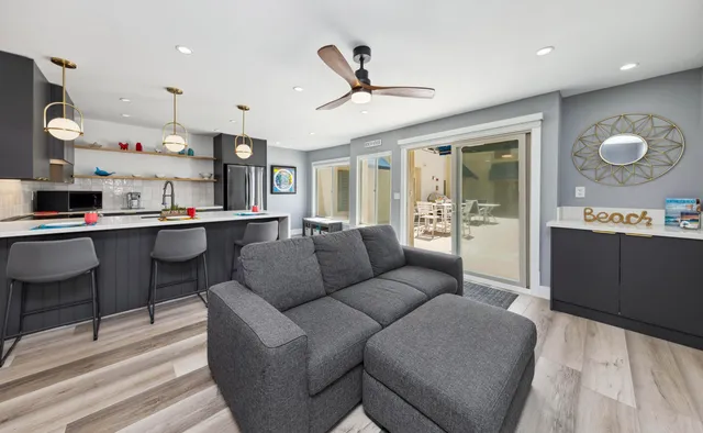 a living room with furniture kitchen view and a chandelier