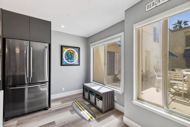 a kitchen with stainless steel appliances granite countertop a refrigerator a sink dishwasher a dining table and chairs with wooden floor