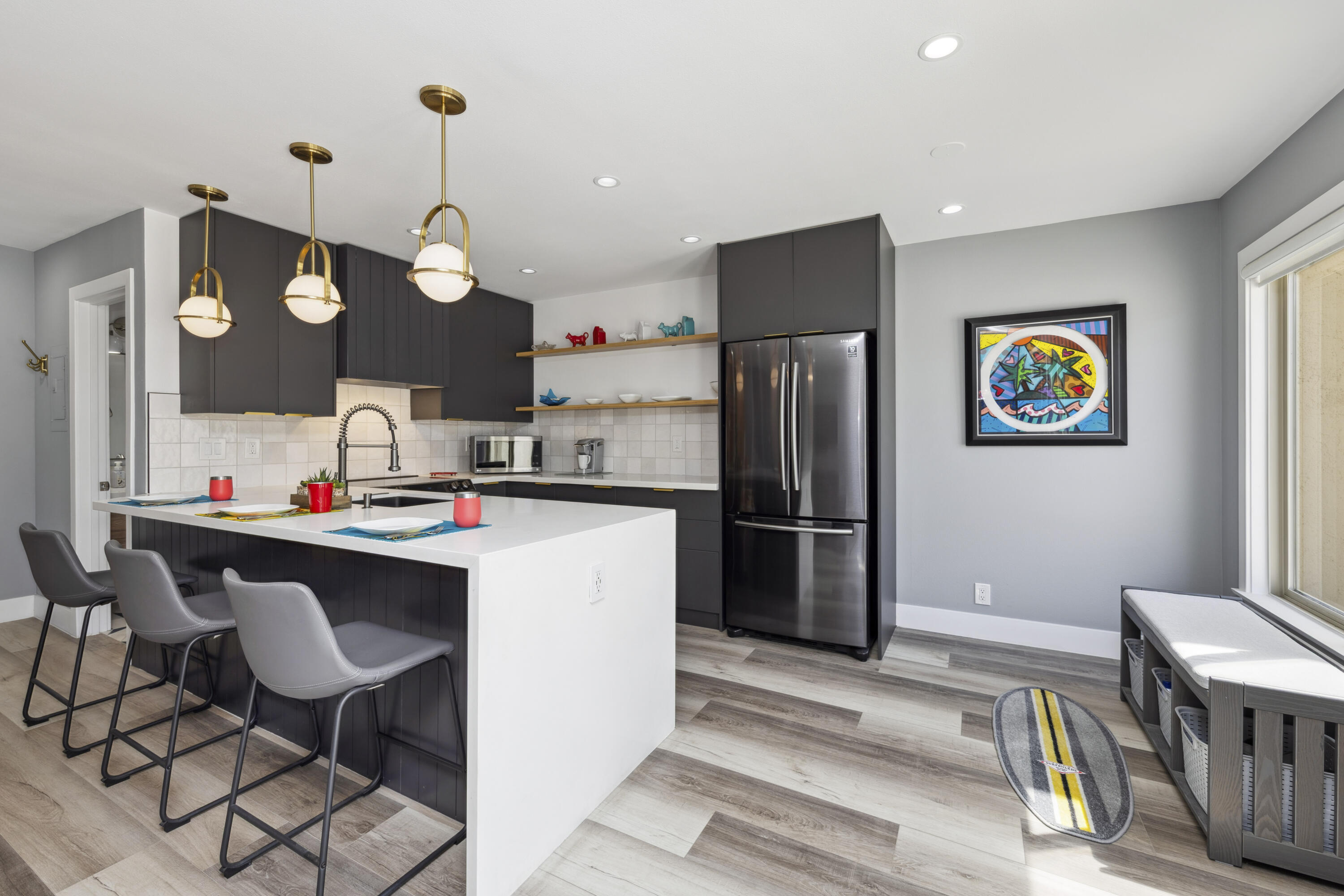 711 Pacific Coast Highway, Unit 206 Huntington Beach, CA 92648 - Photo 10 of 32 a kitchen with stainless steel appliances granite countertop a refrigerator a sink dishwasher a dining table and chairs with wooden floor