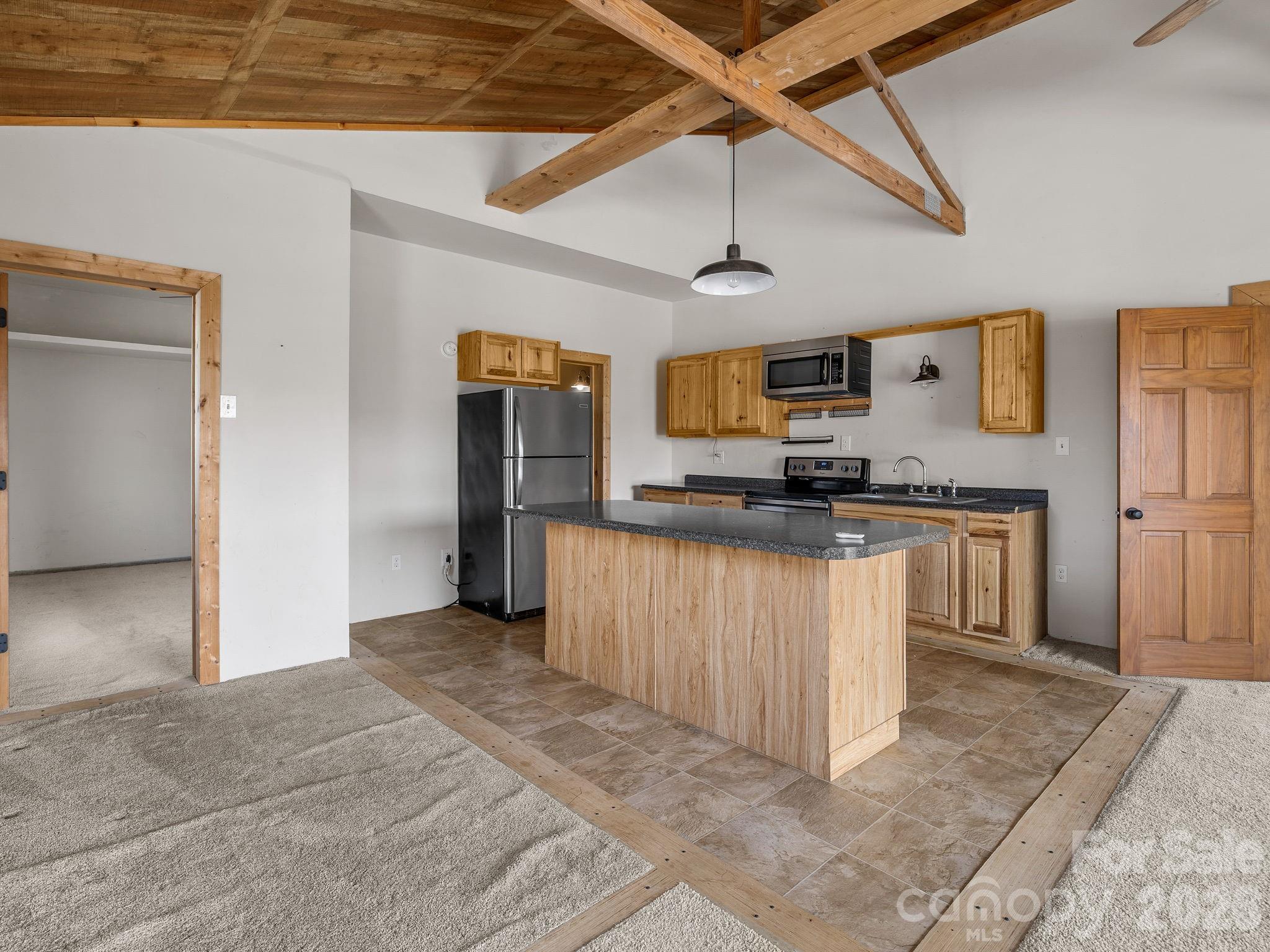 1487 Hayes Road Columbus, NC 28722 - Photo 13 of 48 a kitchen with granite countertop a refrigerator and a stove top oven