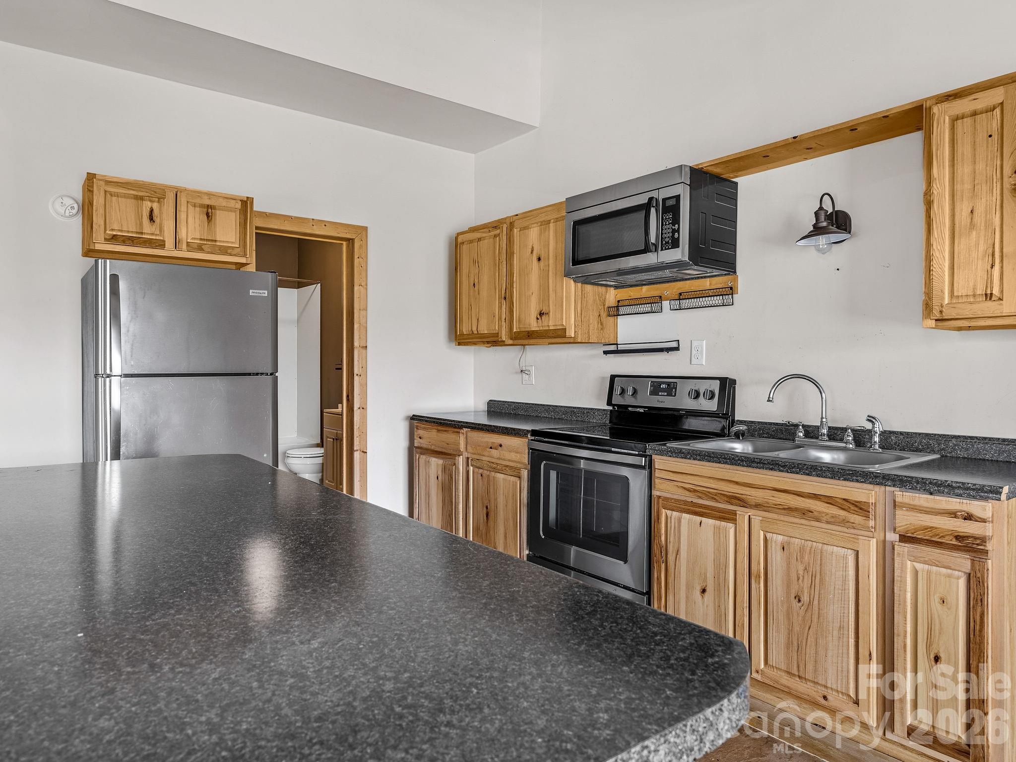 1487 Hayes Road Columbus, NC 28722 - Photo 14 of 48 a kitchen with stainless steel appliances granite countertop a refrigerator a stove a sink and a microwave