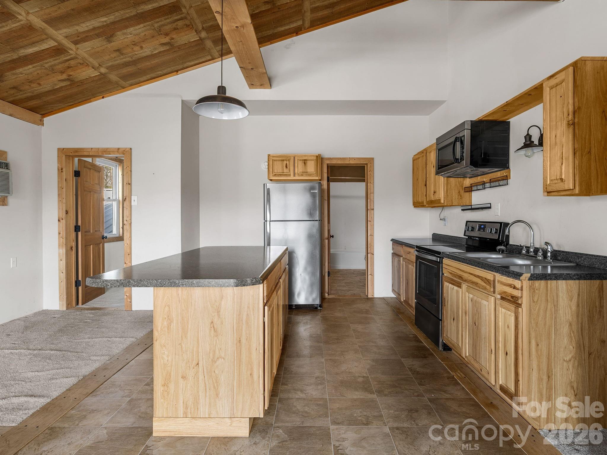 1487 Hayes Road Columbus, NC 28722 - Photo 15 of 48 a kitchen with stainless steel appliances granite countertop a sink and a stove top oven with wooden floor