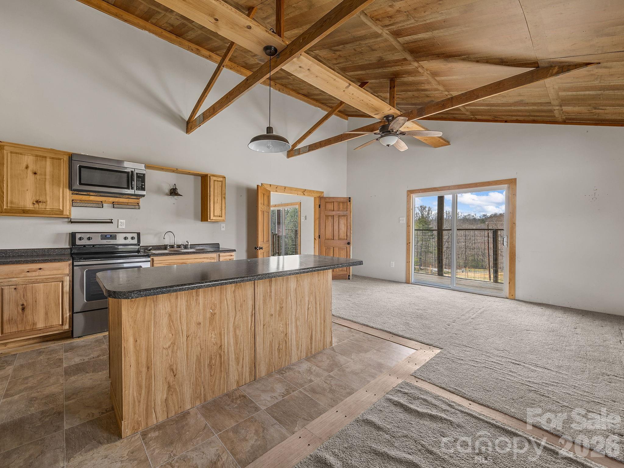 1487 Hayes Road Columbus, NC 28722 - Photo 16 of 48 a kitchen with stainless steel appliances granite countertop a stove cabinets and a refrigerator