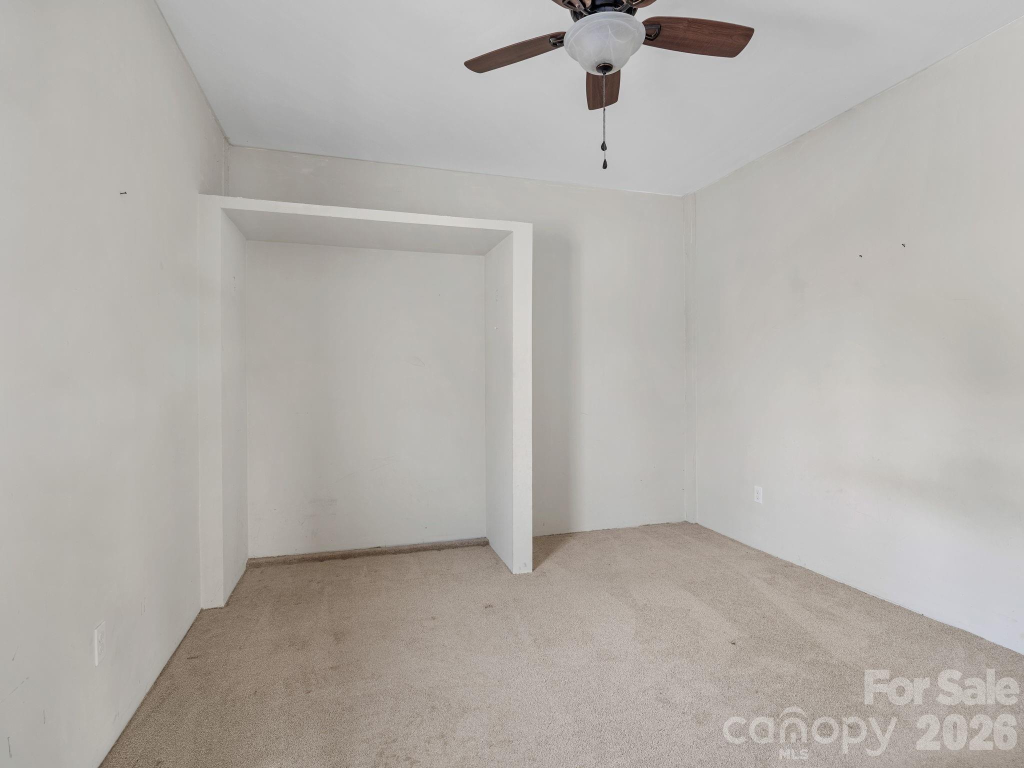 1487 Hayes Road Columbus, NC 28722 - Photo 19 of 48 an empty room with a window and a ceiling fan